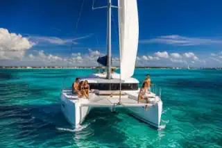 White catamaran sailing across brilliant turquoise Caribbean water