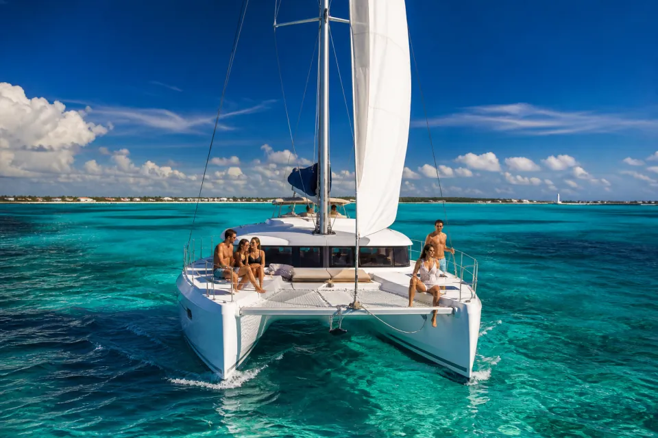 White catamaran sailing across brilliant turquoise Caribbean water